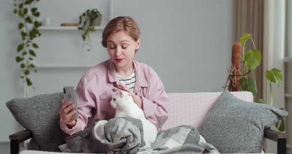 Young Woman Freelance Blogger Shoots Video on Mobile Smartphone Speaks on Video Chat Conference alt