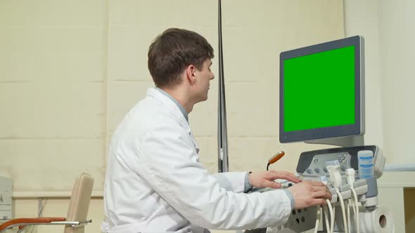 Young Male Doctor Using Ultrasound Scanner with Green Screen alt