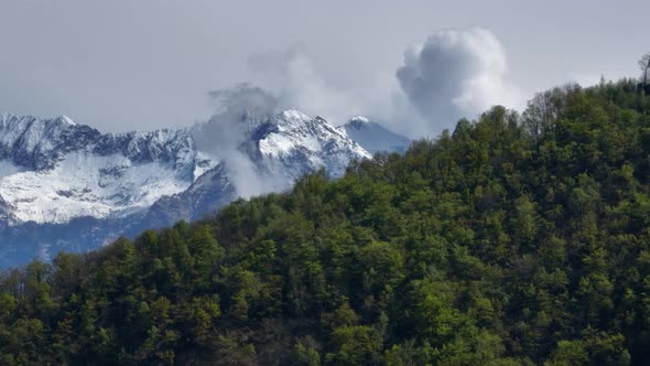 Scenic green ridge revealing clouds enveloping pointed Alp mountain top; drone alt