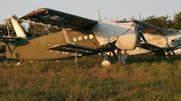 A Ruined Rustgreen Antonov2 Plane Stands on the Grass of an Airfield at an Abandoned Military