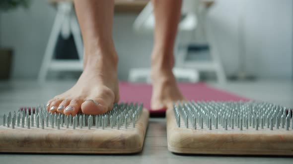 Closeup of Woman's Feet Stepping on Sadhu Board During Enjoyable Indian Practice at Home alt