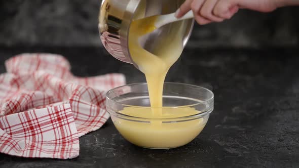 Pouring Vanilla Pudding Into Bowl. alt