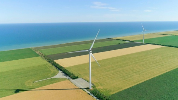 Group of windmills for electric power production in the agricultural fields. Aerial view.