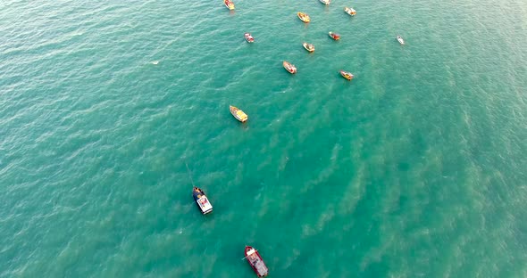 Aerial view of boats navigating around rock pillars in the sea in Portugal. alt