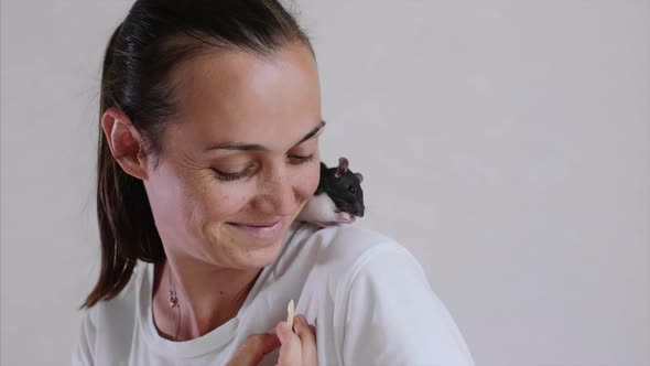 Young Woman and Pet Rat Sitting on Her Shoulder Are Having a Breakfast Together.