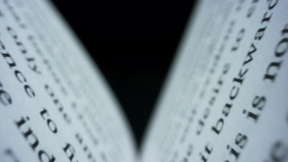 Camera Moving Between Paper Book Pages. Open Book Against Black Background alt