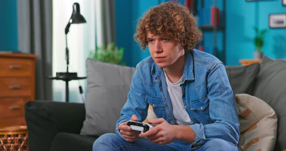 Teenage Boiy With Joystick Playing Videogame On Television At Home alt