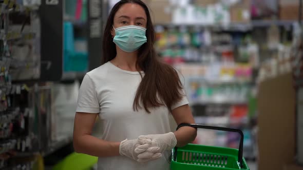Portrait of a Dark-haired, Middle-aged Woman. She Is in a Grocery Store, with a Shopping Basket alt