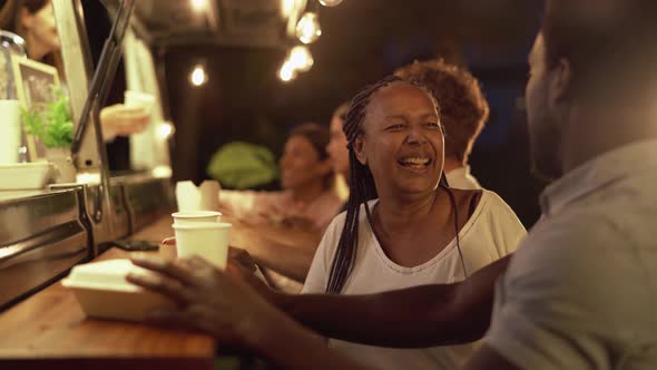 Happy multiracial people buying meal from street food truck market alt