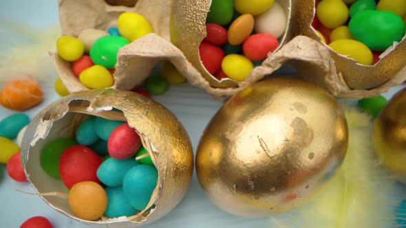 Golden Decorative Easter Eggs Filled with Colorful Candies on Wooden Table Close Up