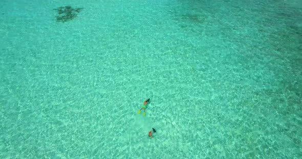 Aerial drone view of a man and woman couple snorkeling with seascooters alt