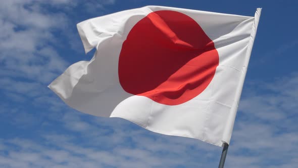 Japanese Flag Waving in the Wind in Slow Motion Close Up with Sky Background alt