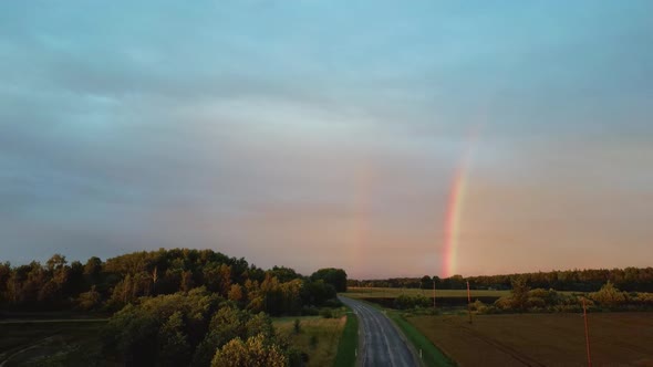 Dark Thunderstorm Clouds and Double Rainbow Over Forest and Wheat Field, Areal Dron Shoot. alt
