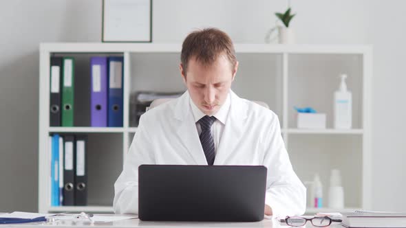 Professional medical doctor working in hospital office using computer technology. alt