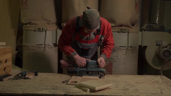 Furniture Factory Worker Processes Polishes a Bar for a Set of Furniture alt