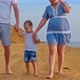 Cheerful Kid Walks Along the Seashore with Mother and Father Walks Barefoot on the Sand - VideoHive Item for Sale