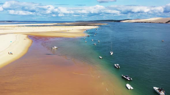 Banc d'Arguin in Arcachon Bay France with boats lined up along the sandbar, Aerial flyover view alt
