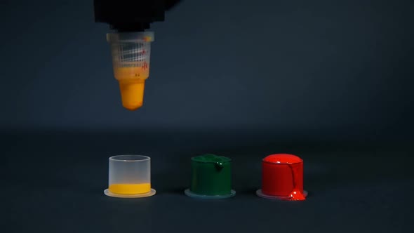 Tattoo Artist Pours Yellow Ink Into A Small Plastic Cup.