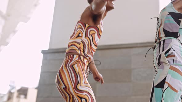 Fashion Models Dancing Together In Brightly Coloured Clothing alt