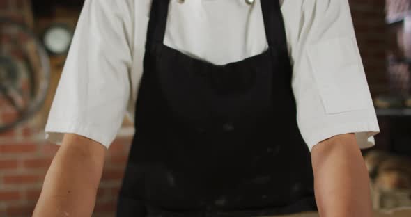 Animation of happy asian female baker rolling sourdough for bread alt
