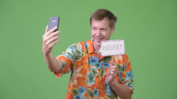 Young Handsome Tourist Man Taking Selfie with Paper Sign alt