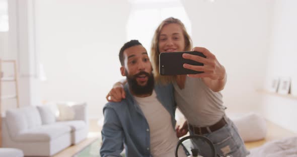 Happy couple taking a selfie indoors alt