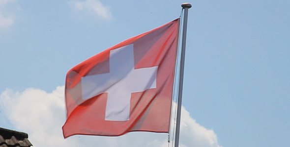 Waving Flag Of Switzerland On Blue Sky