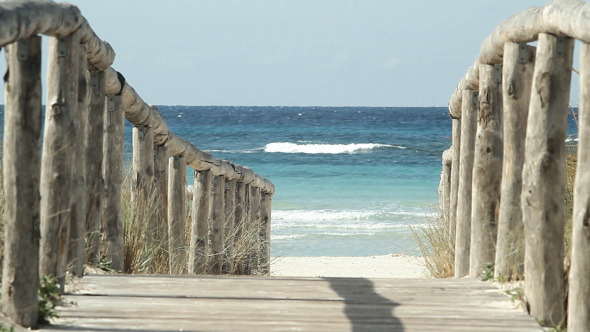 Waves Break On Shore And Wooden Path To Beach alt