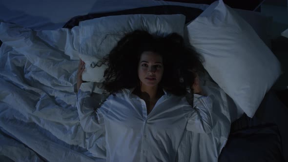 Woman in Mens Shirt Falling on Bed and Posing for Camera in the Dark alt