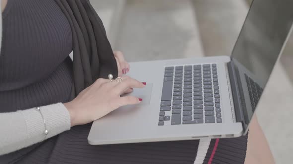 Close Up Shot Of A Woman Typing On A Laptop Outside In Slowmotion - Ungraded alt