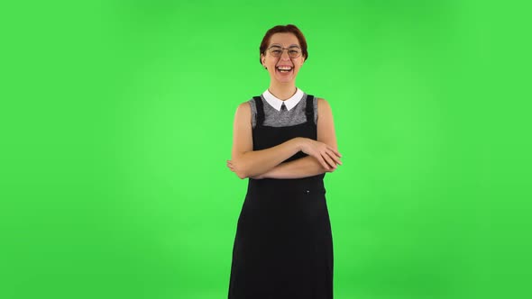 Funny Girl in Round Glasses Communicates with Someone in a Friendly Manner. Green Screen alt