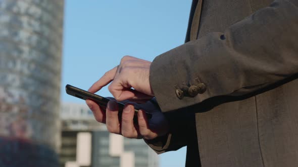 Businessman Hands Using Smartphone on Street. Employee Typing Message on Phone alt