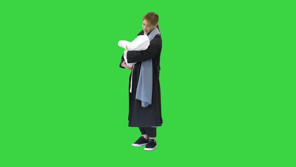 Young Mother with Her Baby Child Outdoors at Winter on a Green Screen, Chroma Key. alt