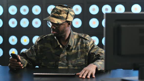 Mature Serious Africanamerican Man Wearing Military Uniform Uses Smartphone