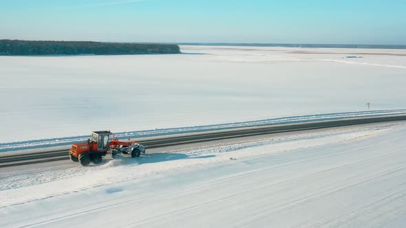 Aerial View Snow Removal Tractor Clears Road From Snow alt