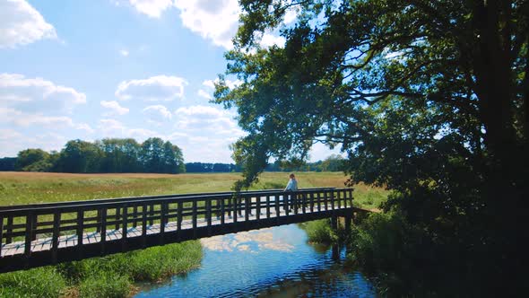 Slow motion clip of a girl walking on a little bridge in the area of Assen, Netherlands. alt