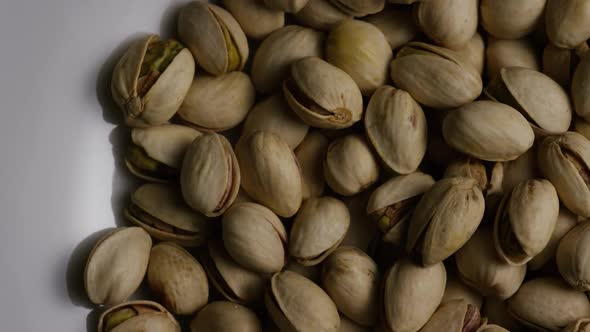 Cinematic, rotating shot of pistachios on a white surface - PISTACHIOS 030 alt