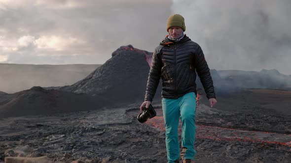 Photographer Walking In Front Of Lava Flow From Erupting Fagradalsfjall Volcano alt