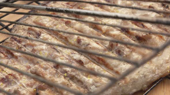 Barbeque Grid with Mackerel Fish is Opening on the Background the Wooden Table alt