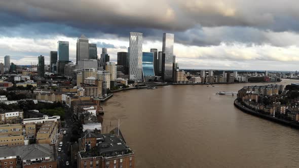 Aerial view of stormy dark clouds over Canary Wharf, approaching London financial District alt