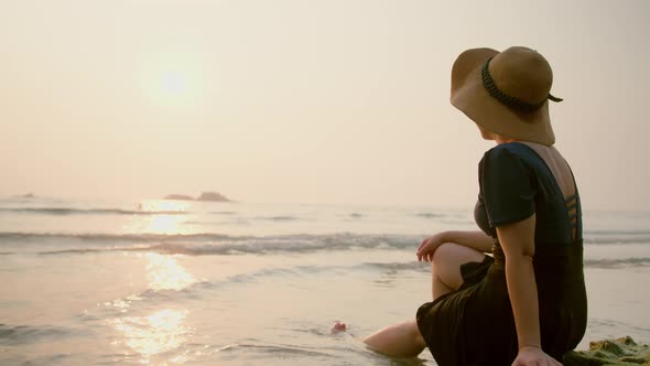 Happiness clam asian female traveller casual cloth with sun hat sit relax enjoy alt