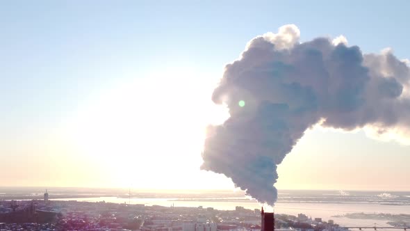 Chimneys of a Factory or Power Plant Produce Smoke at Sunrise Aerial View From a Drone