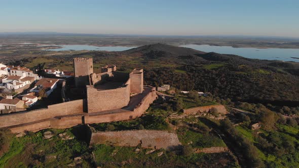 Panning over the Castle of Monsaraz and the beautiful village below filled with white walls and hist alt