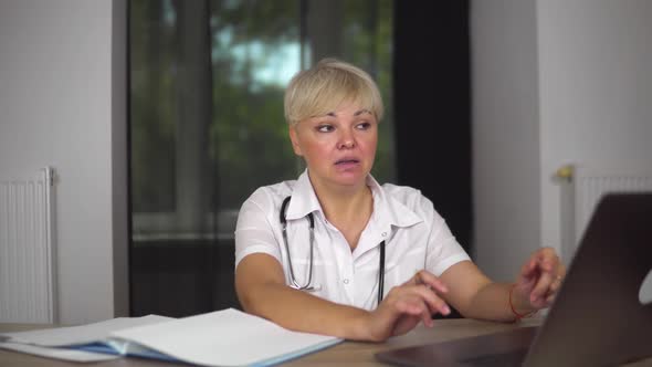 The Emotional Doctor in Medical Gown is Talking with Patient