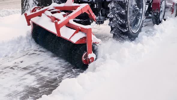 City Service Cleaning Snow a Small Tractor with a Rotating Brush Clears a Road in the City Park From