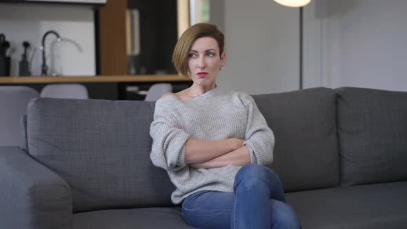 Portrait of Displeased Angry Slim Attractive Woman Sitting on Couch Looking Away Hitting Fist on alt