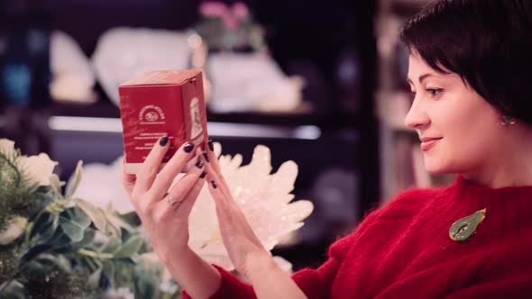 Pretty Brunette Woman Chooses a New Year Gift in the Store and Smile Cinematic Shot