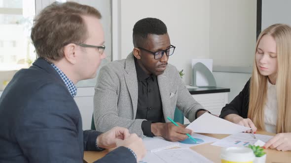 Business People Meeting African Man and Caucasian Man and Woman Check Sales