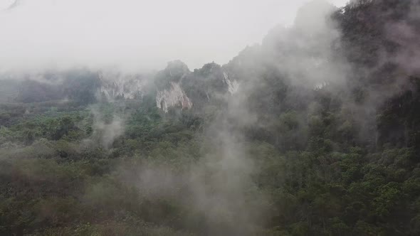 Flying Through Tropical Thailand Valley with Mist Clouds in a Rainy Day