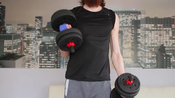 Man using dumbbells doing workout at home. Young man training biceps.